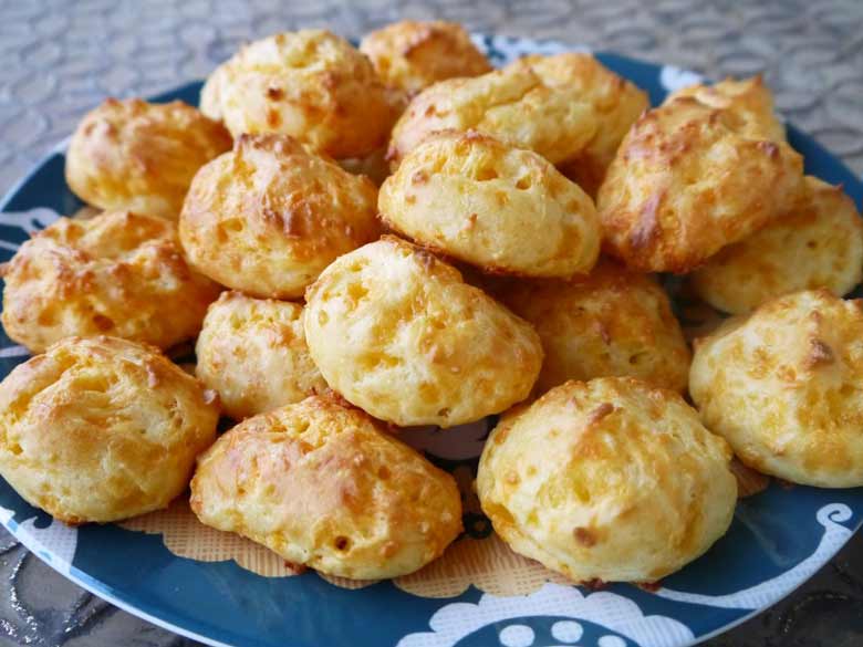 Gougeres on a plate stacked on top of each other.