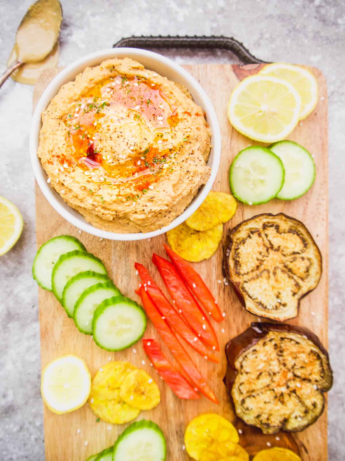 Paleo hummus on a serving tray with veggies and chips to dunk into it.