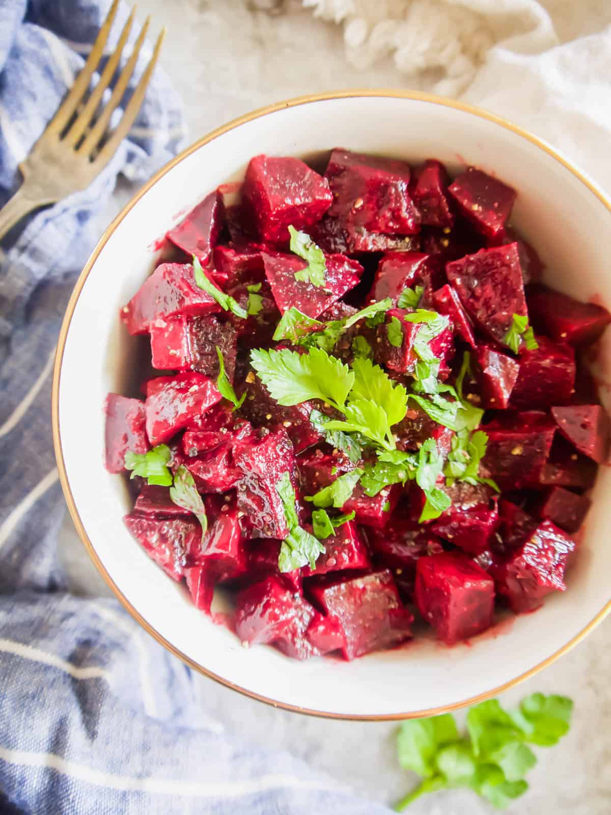 French Beet Salad in a bowl with herbs on top.