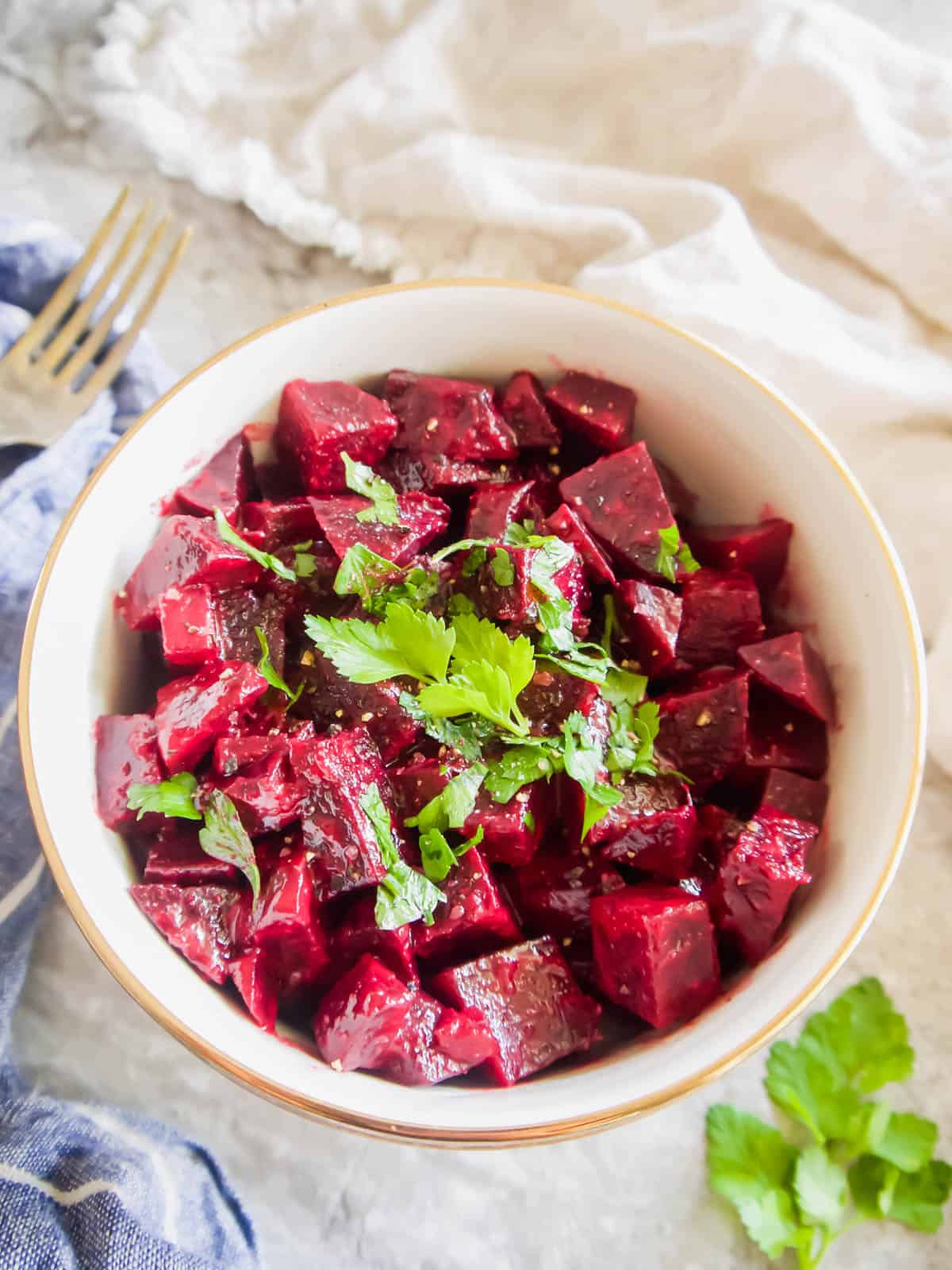 Boiled beet salad in a bowl with a fork on the side.