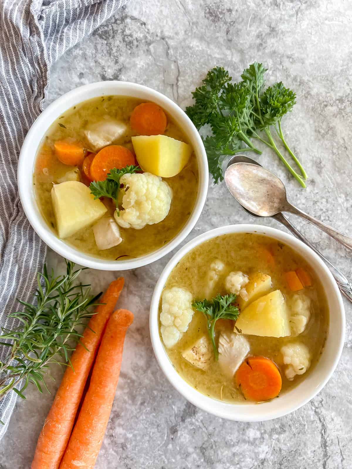 Healthy chicken soup made without noodles in two bowls.