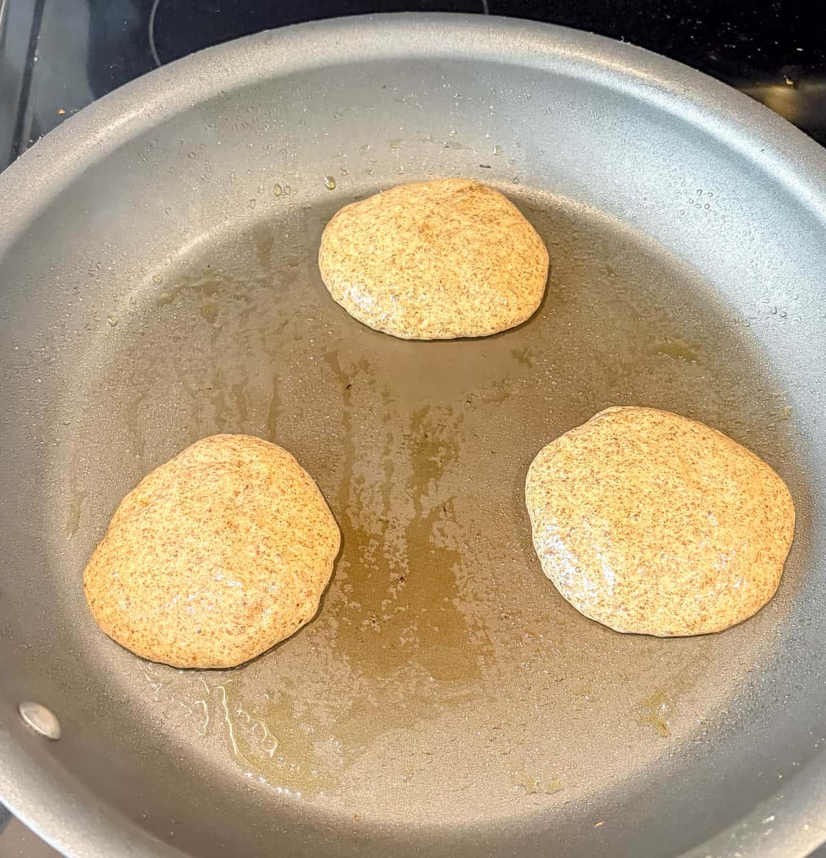 Cooking chia flax protein pancakes in a pan.