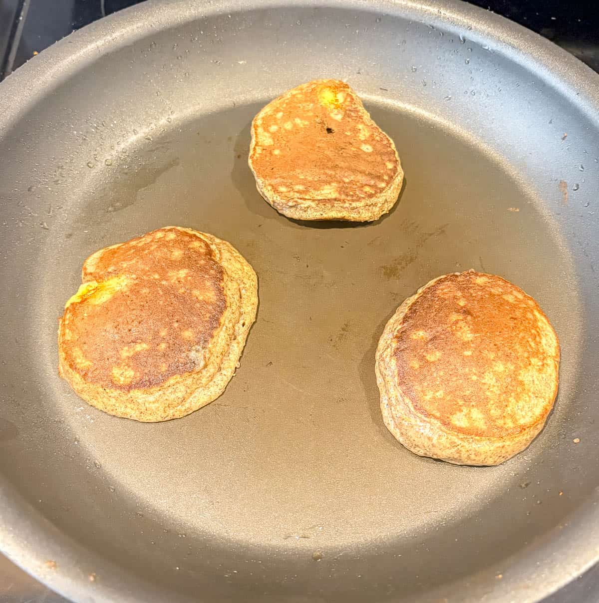 Flipping chia flax protein pancakes in a pan.
