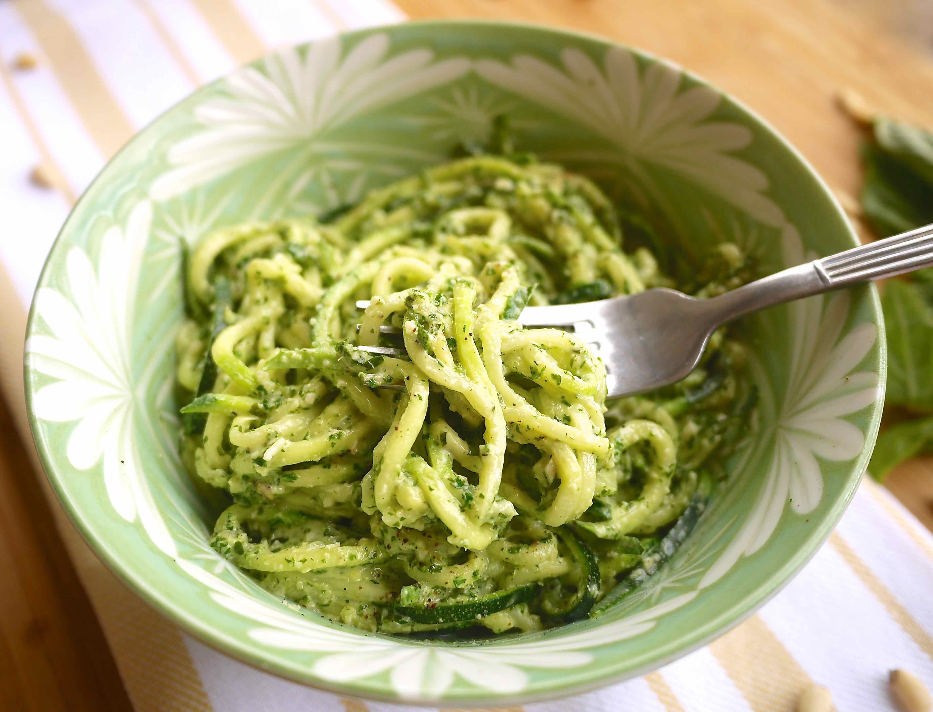 Lemon pesto zoodles in a bowl with fork in the bowl.