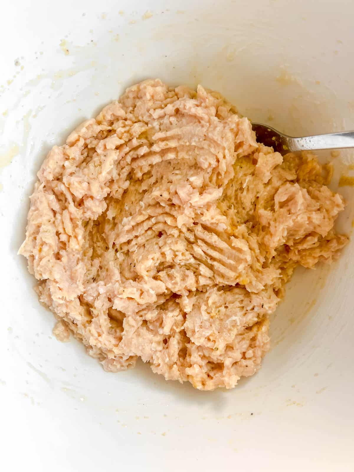 Ground chicken burger mixture in a bowl.