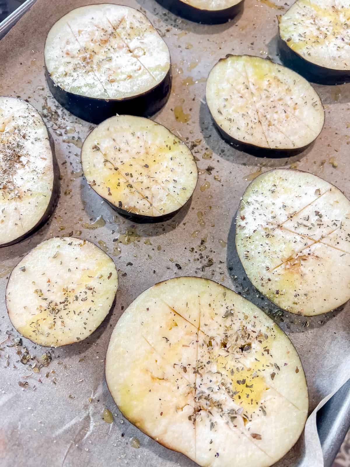 Eggplant with olive oil and spices on top before baking.