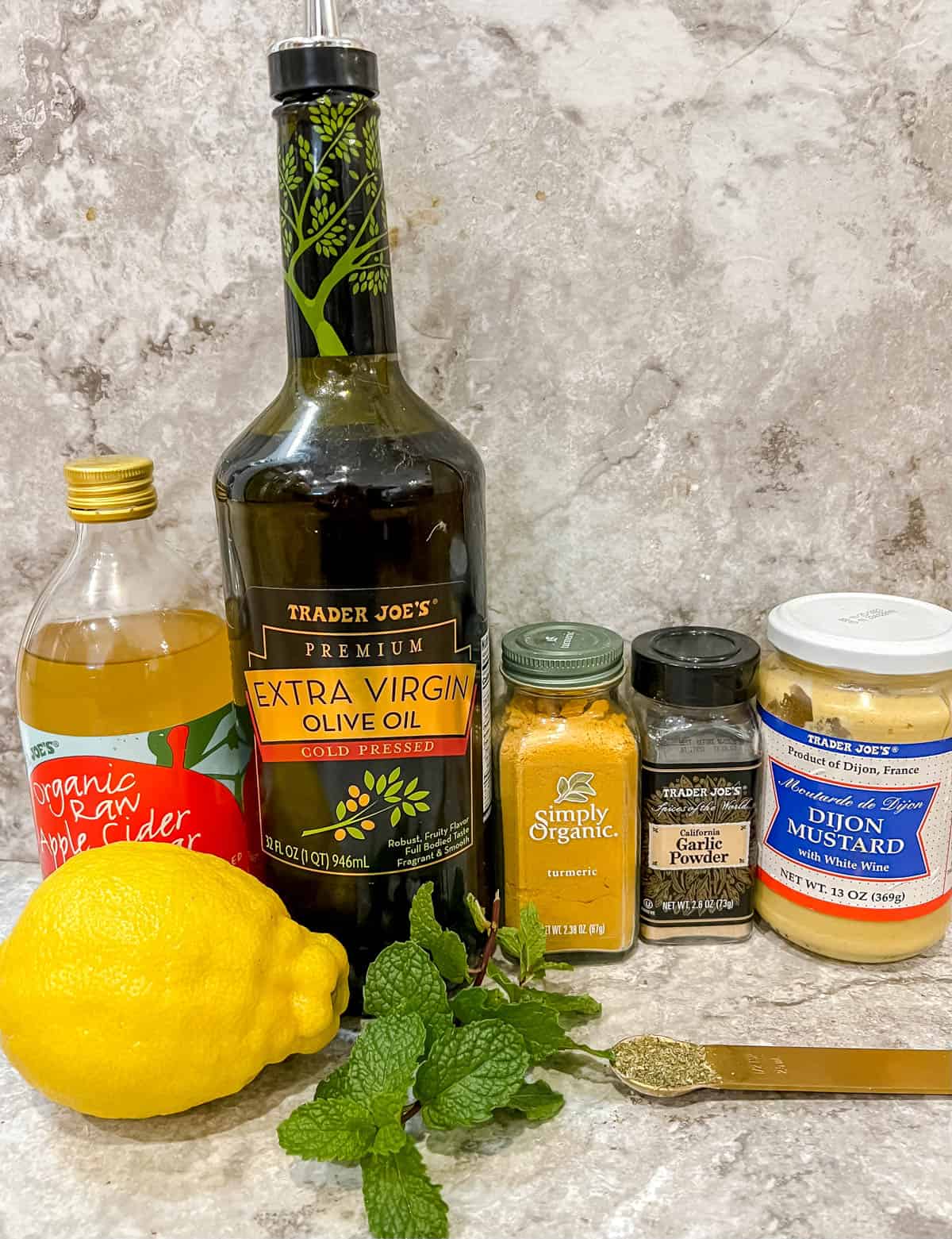 Ingredients needed to make a lemon turmeric dressing with mint.