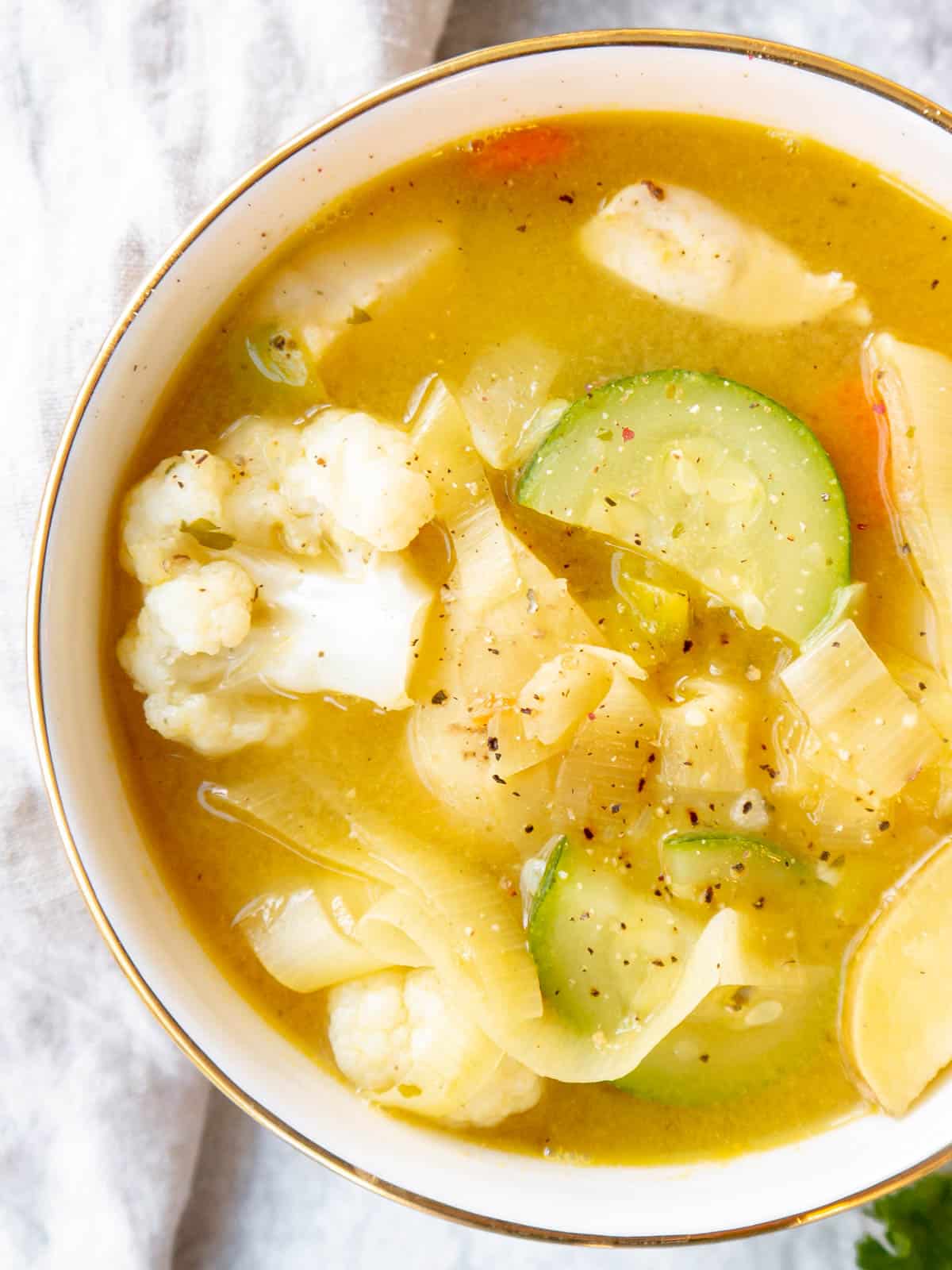 Chicken leek soup in a bowl with potatoes, carrots and zucchini. 