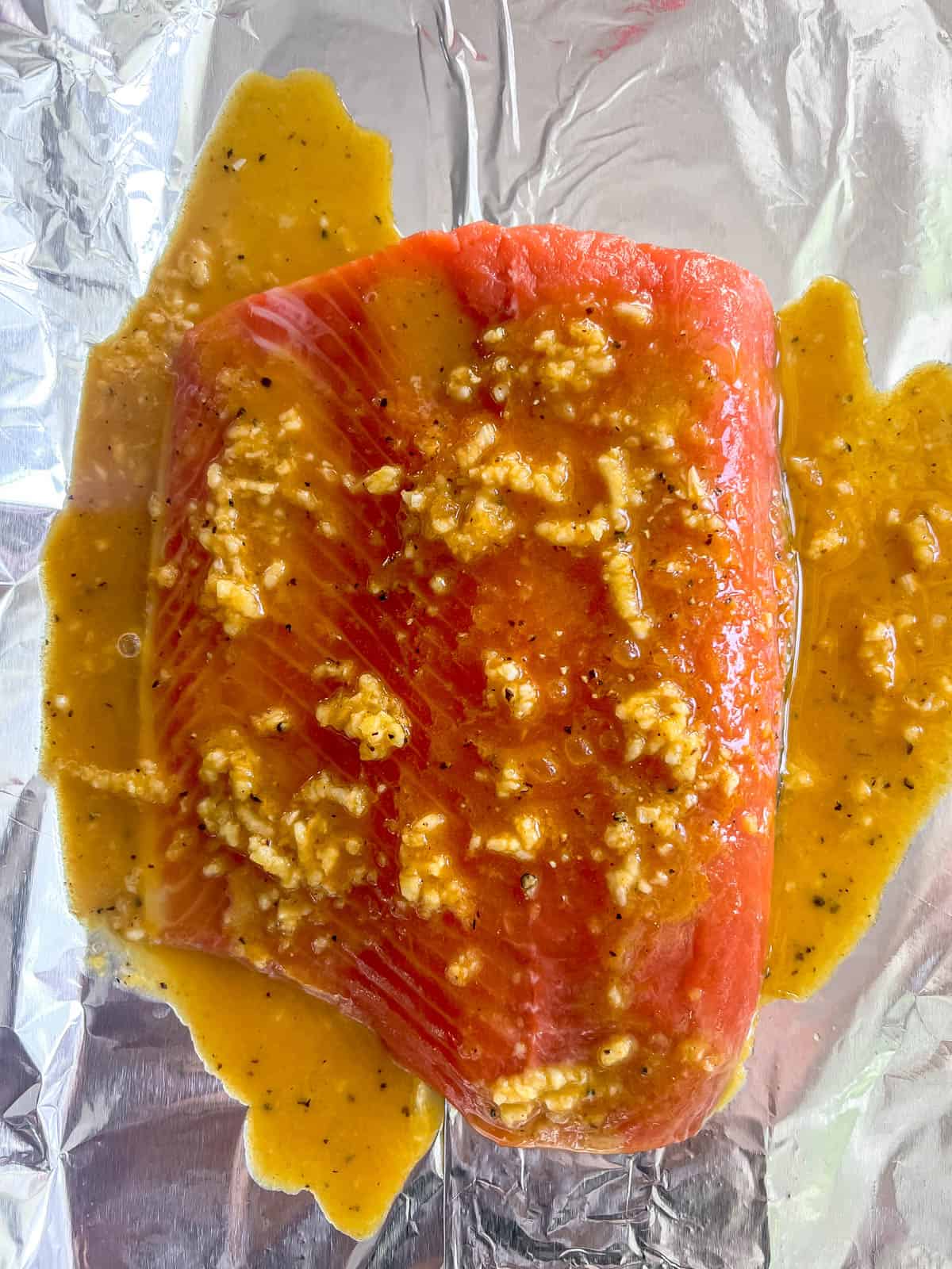 Salmon on foil with turmeric ginger sauce.