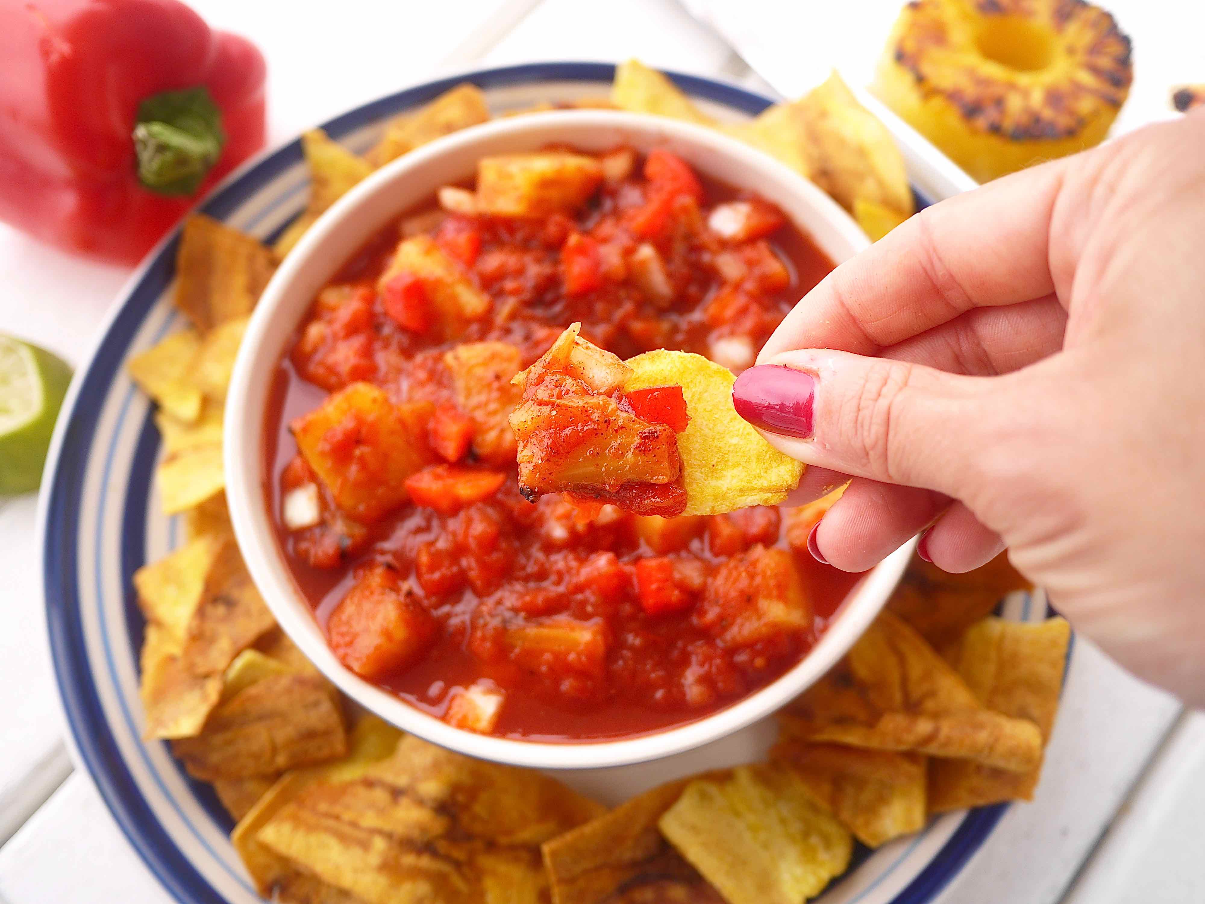 A chip dunked into fresh pineapple salsa.