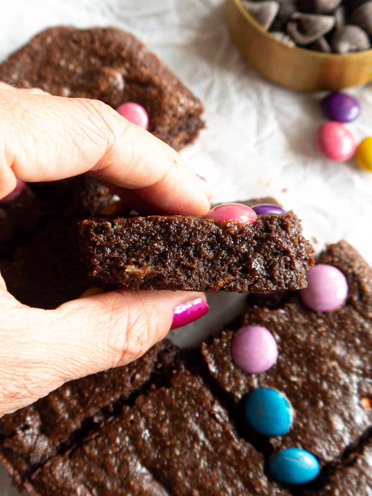 A slice of gluten free brownies made with almond flour in someone's hands.