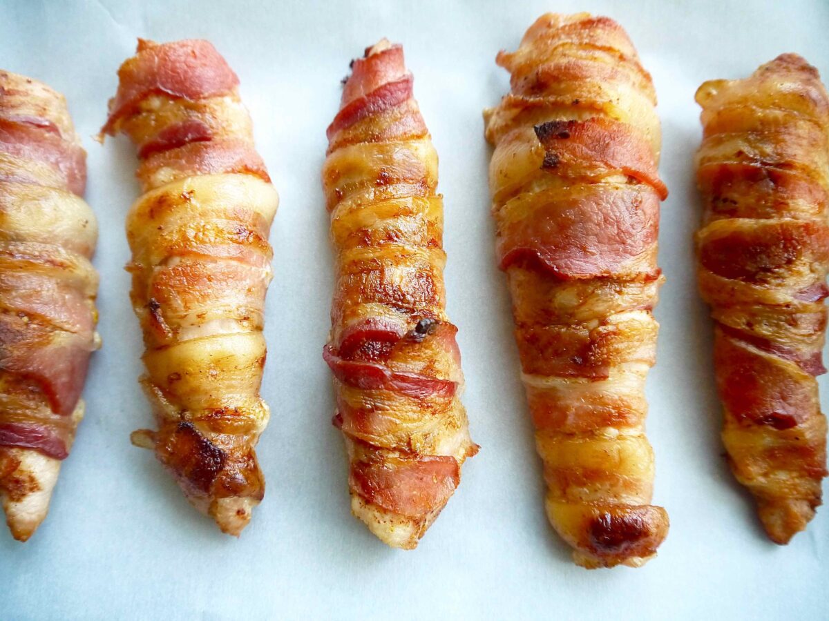Freshly baked bacon wrapped chicken tenders in oven.