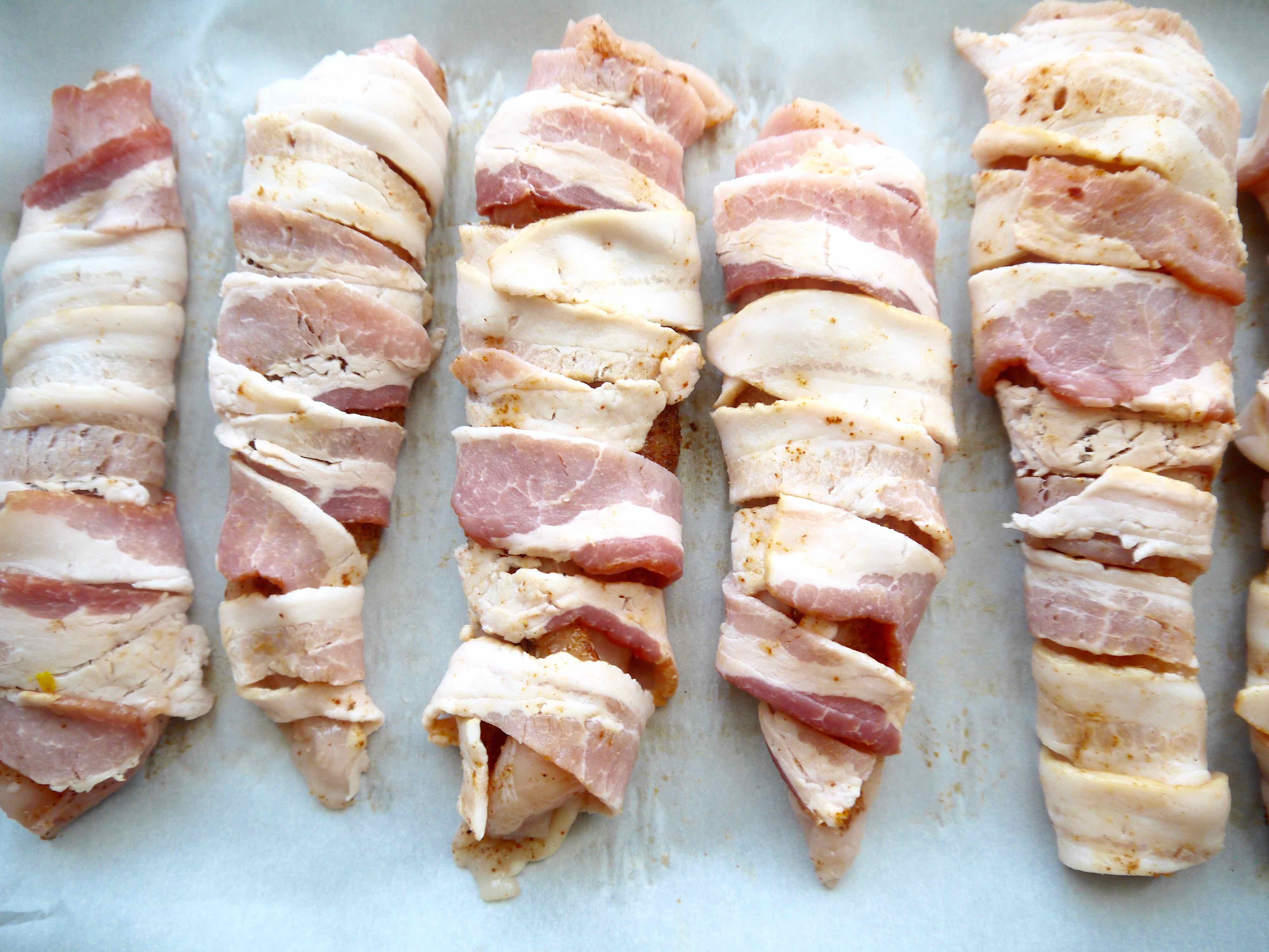 Chicken wrapped in bacon before cooking.