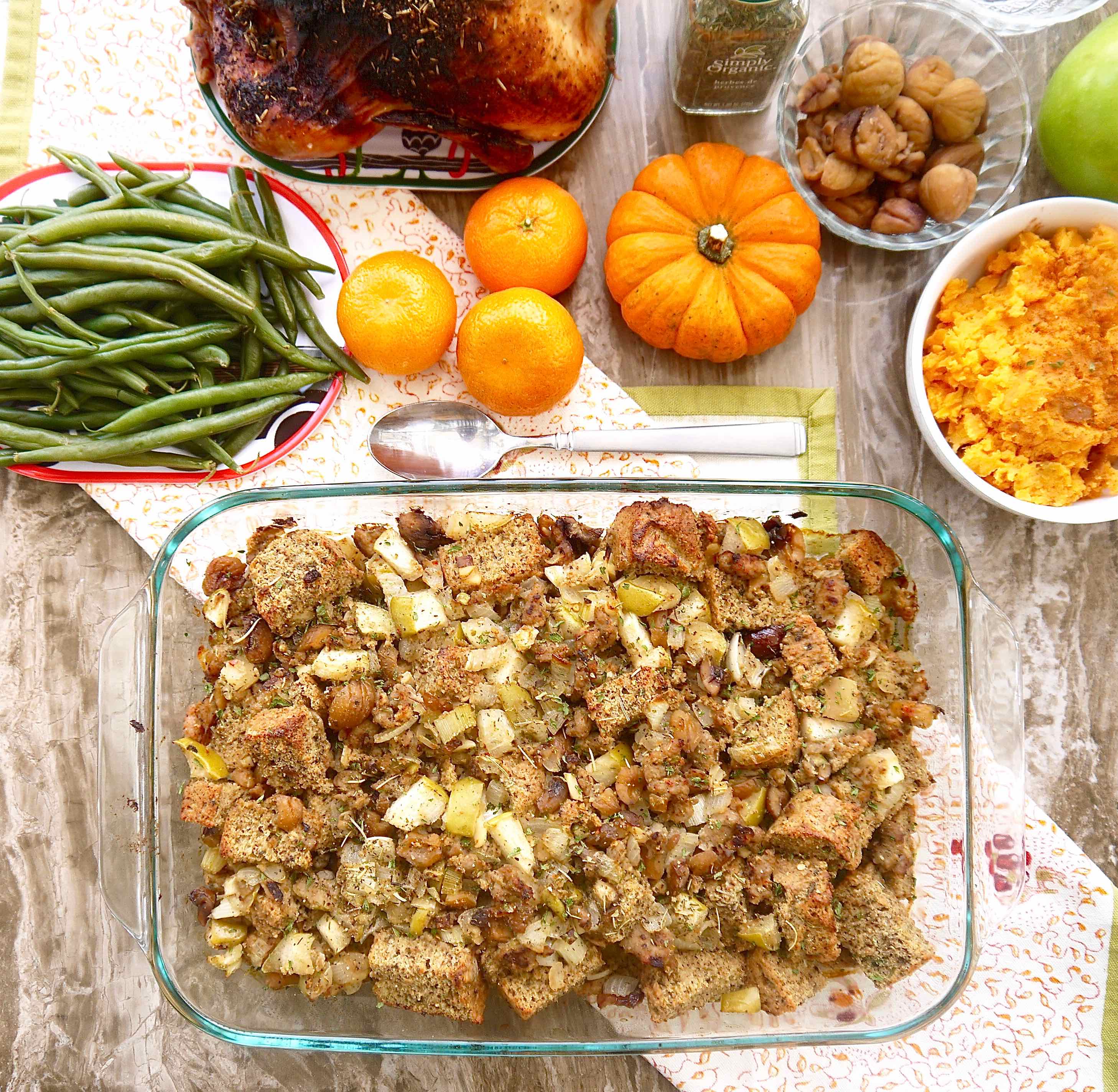 Gluten-free chestnut stuffing with sausage in a large pan, with other sides near it.