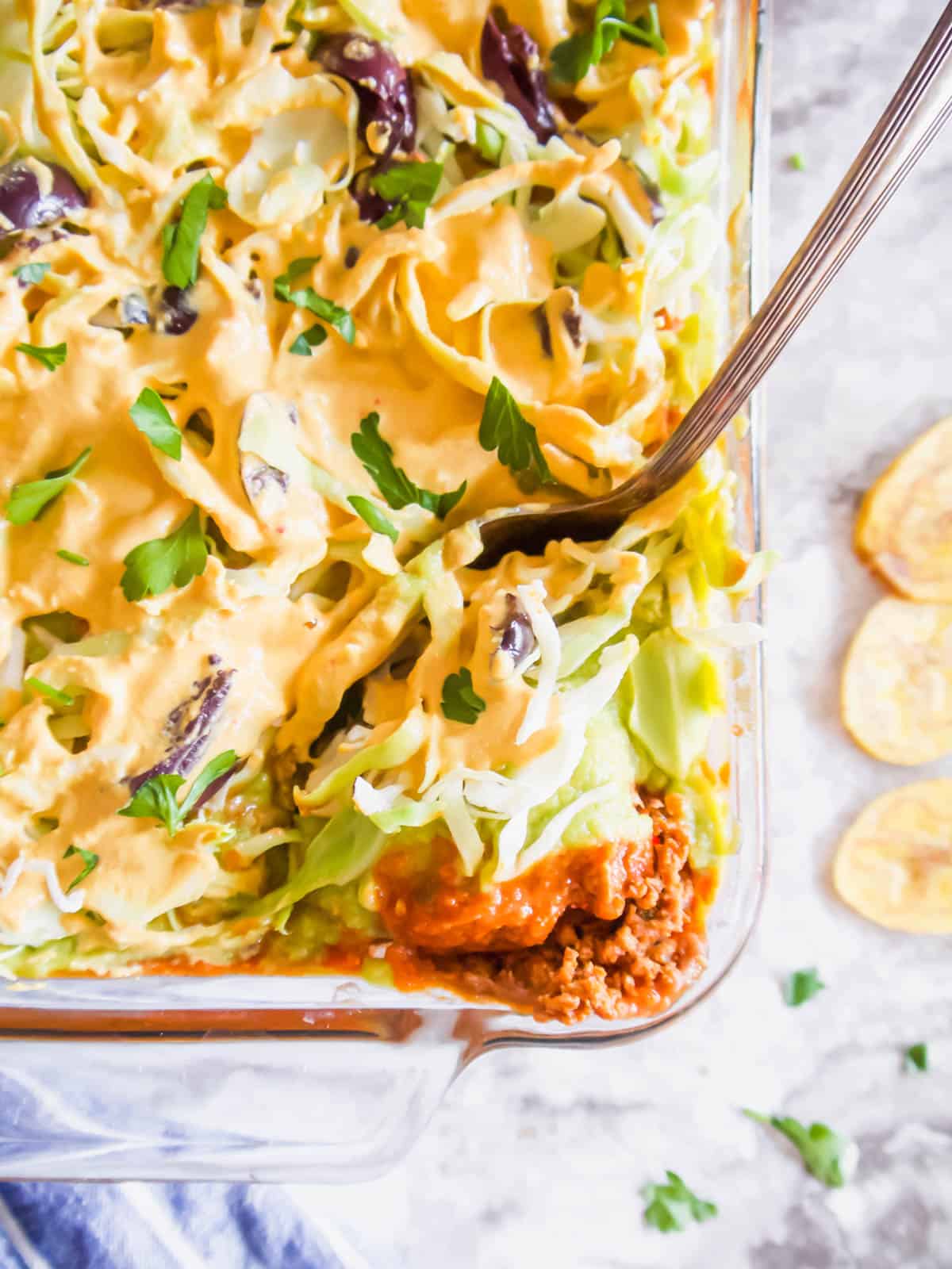 Dairy free taco dip in a pan with a spoon inside of it.