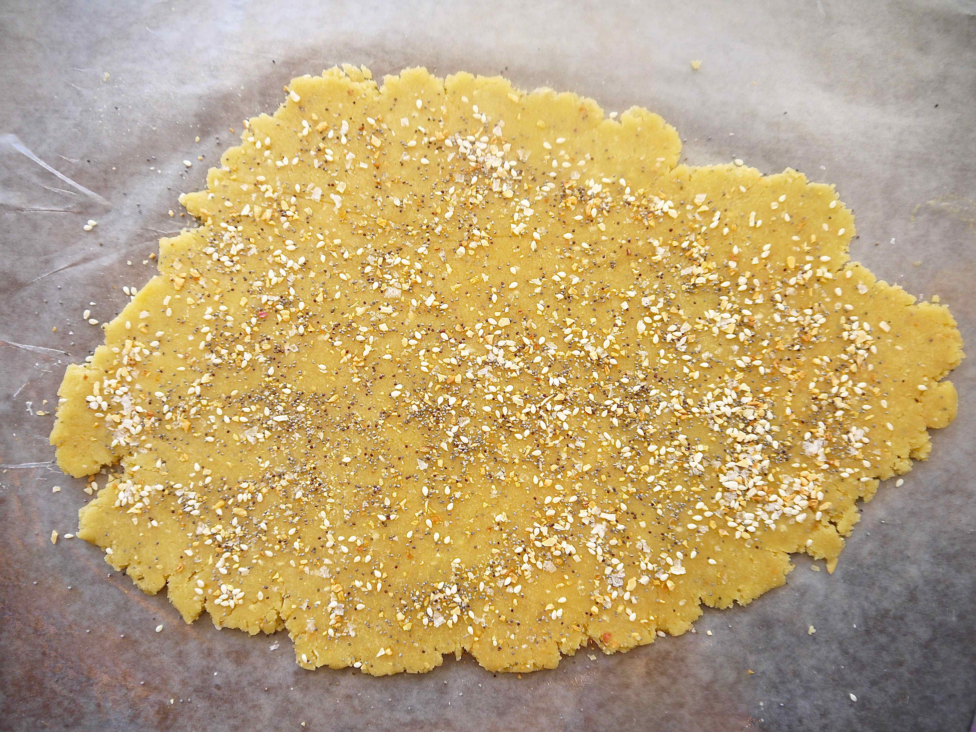 Almond flour cracker dough rolled out flat with bagel seasoning on top.