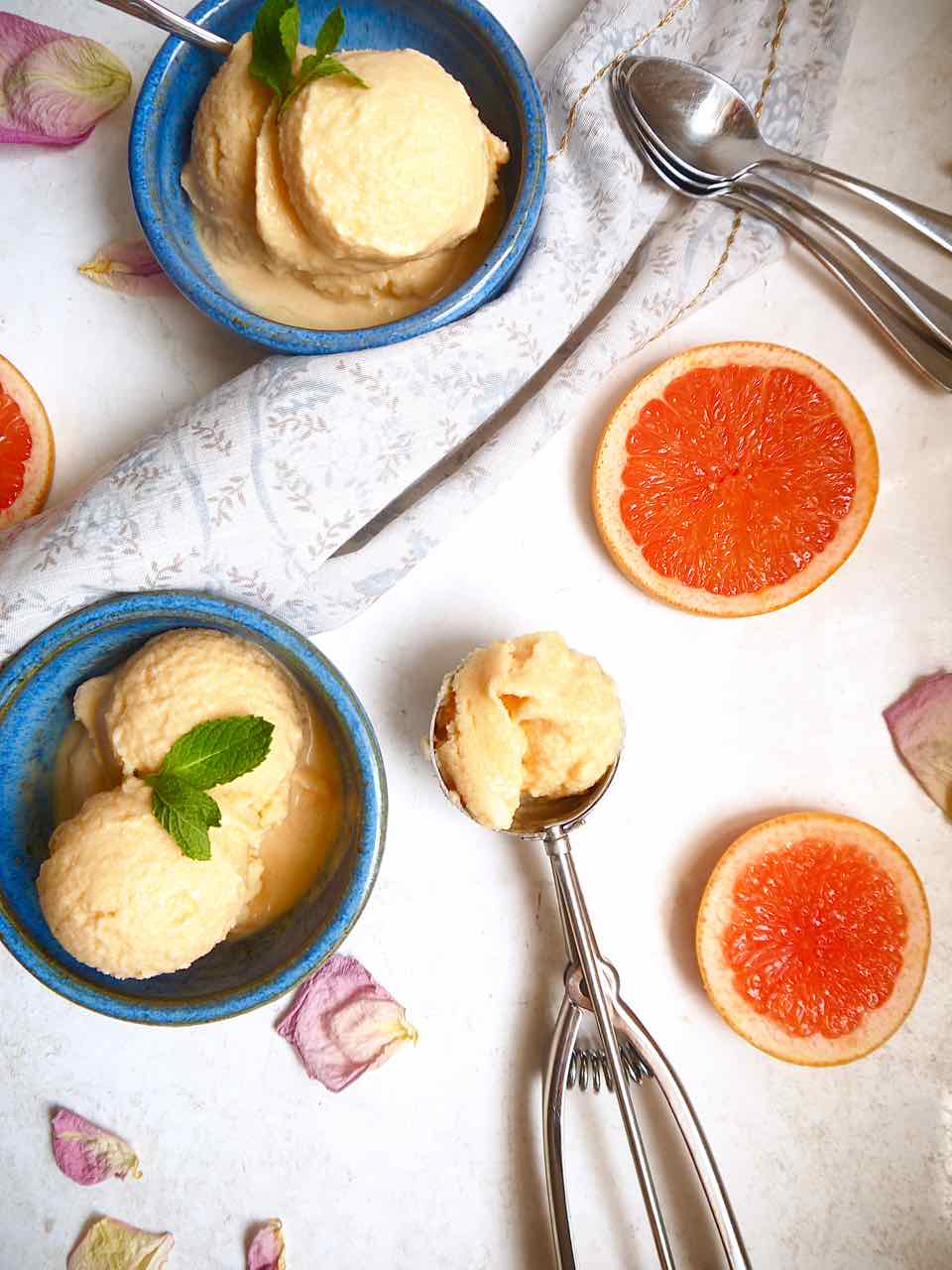 Grapefruit sorbet in an ice-cream scoop and bowl.