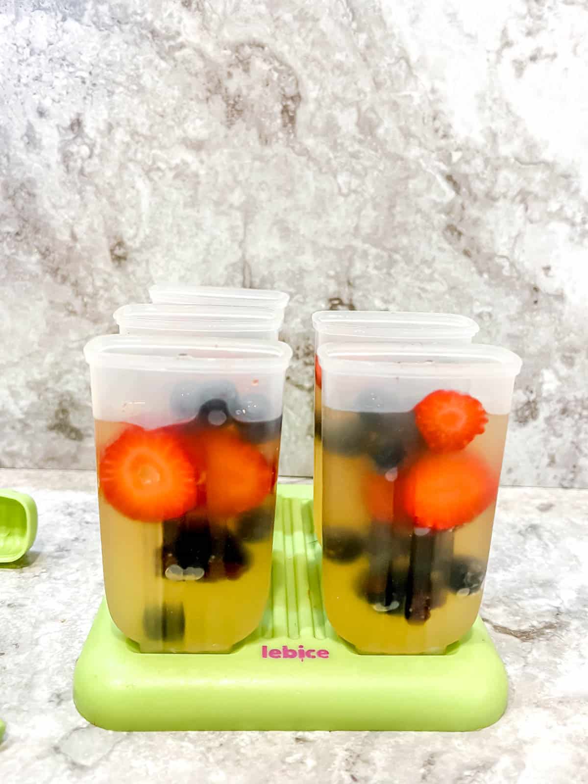 Apple juice poured into popsicle molds.