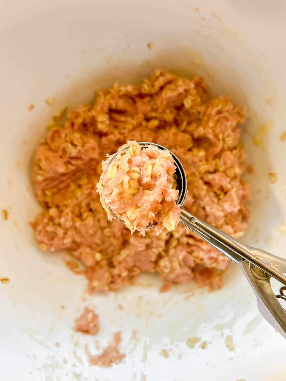 Scooping the mixture into meatballs.