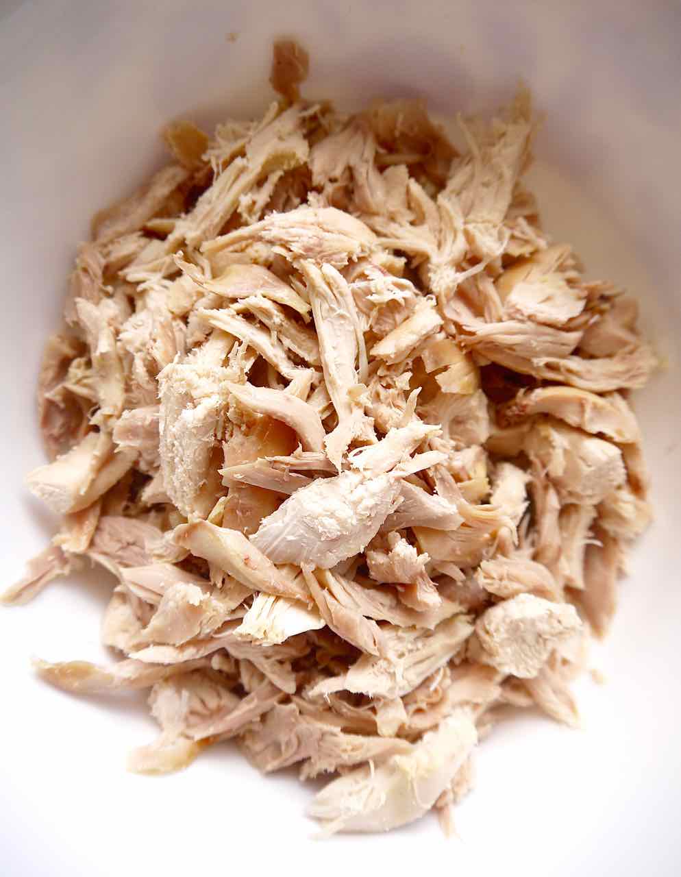 Rotisserie chicken meat in small pieces in a bowl.