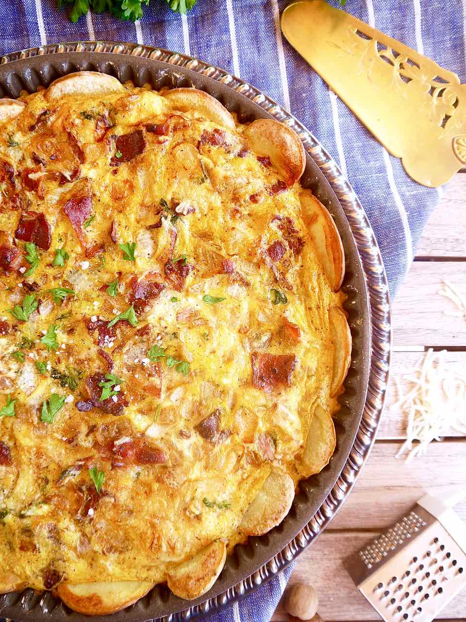 Cooked quiche Lorraine with sliced potato crust.