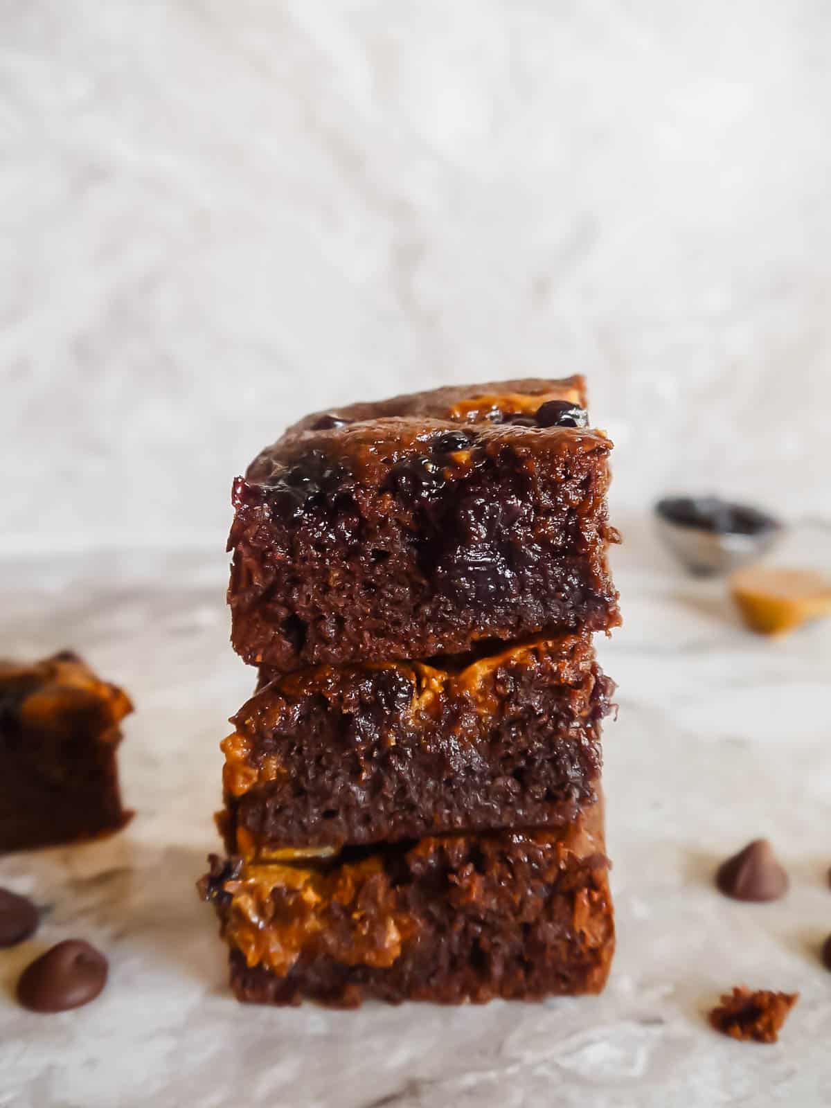 Almond flour brownies recipe with almond butter and jelly. Brownies stacked on top of each other. 