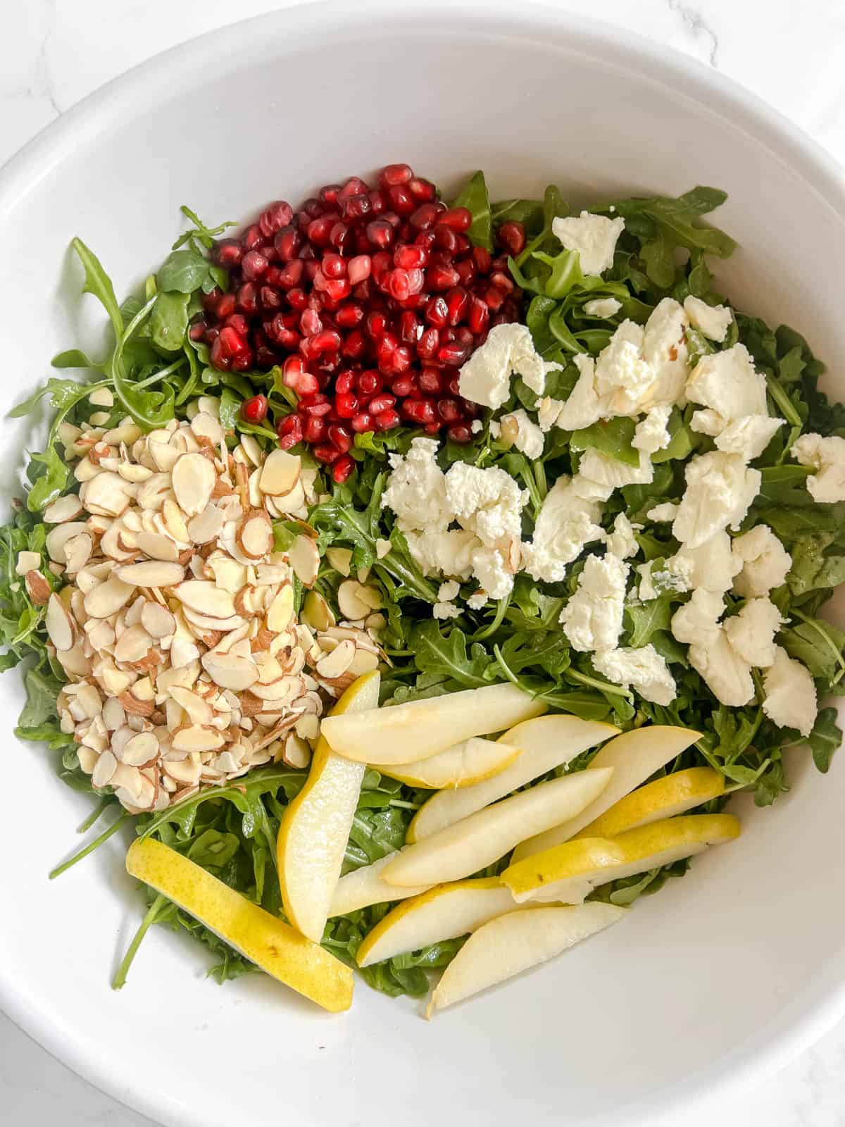 Toppings added to the pear pomegranate salad.