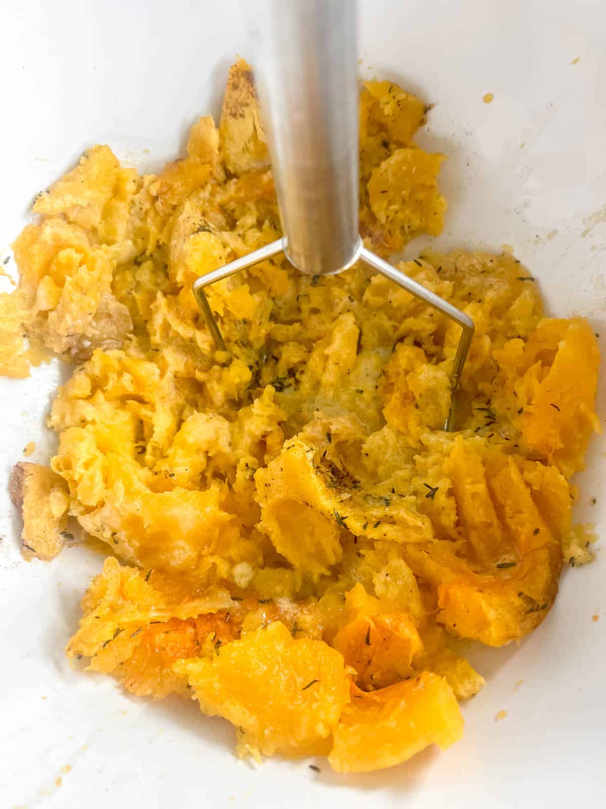 Butternut squash mash ingredients in a bowl after mashing.