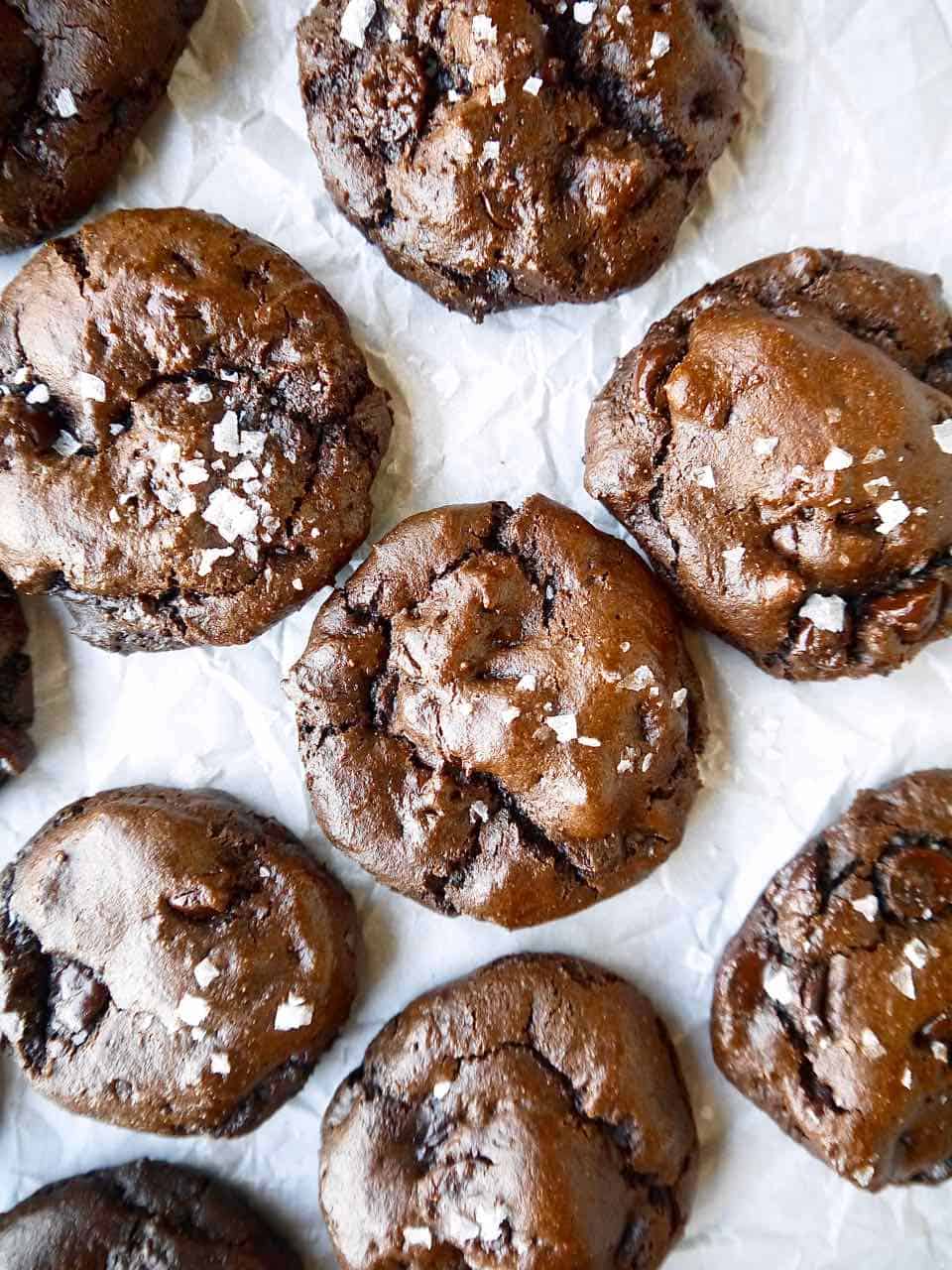 Freshly baked paleo chocolate cookies on parchment paper.