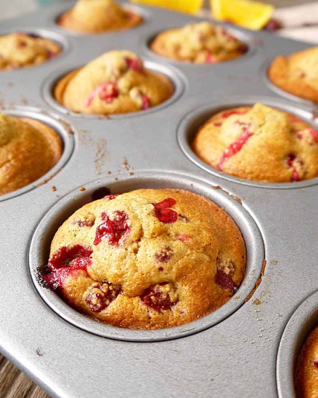 Orange cranberry muffins in a muffin tin.
