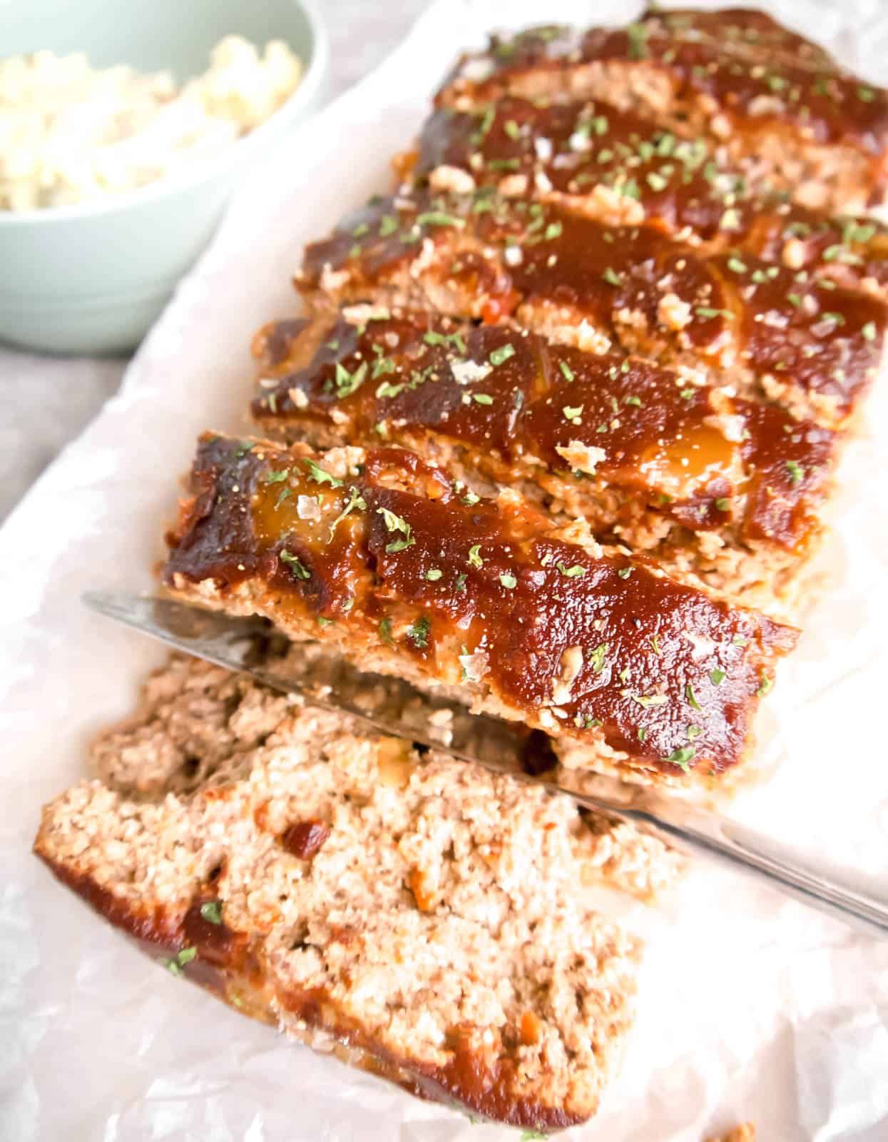 Paleo meatloaf covered in meatloaf sauce sliced and ready to serve.