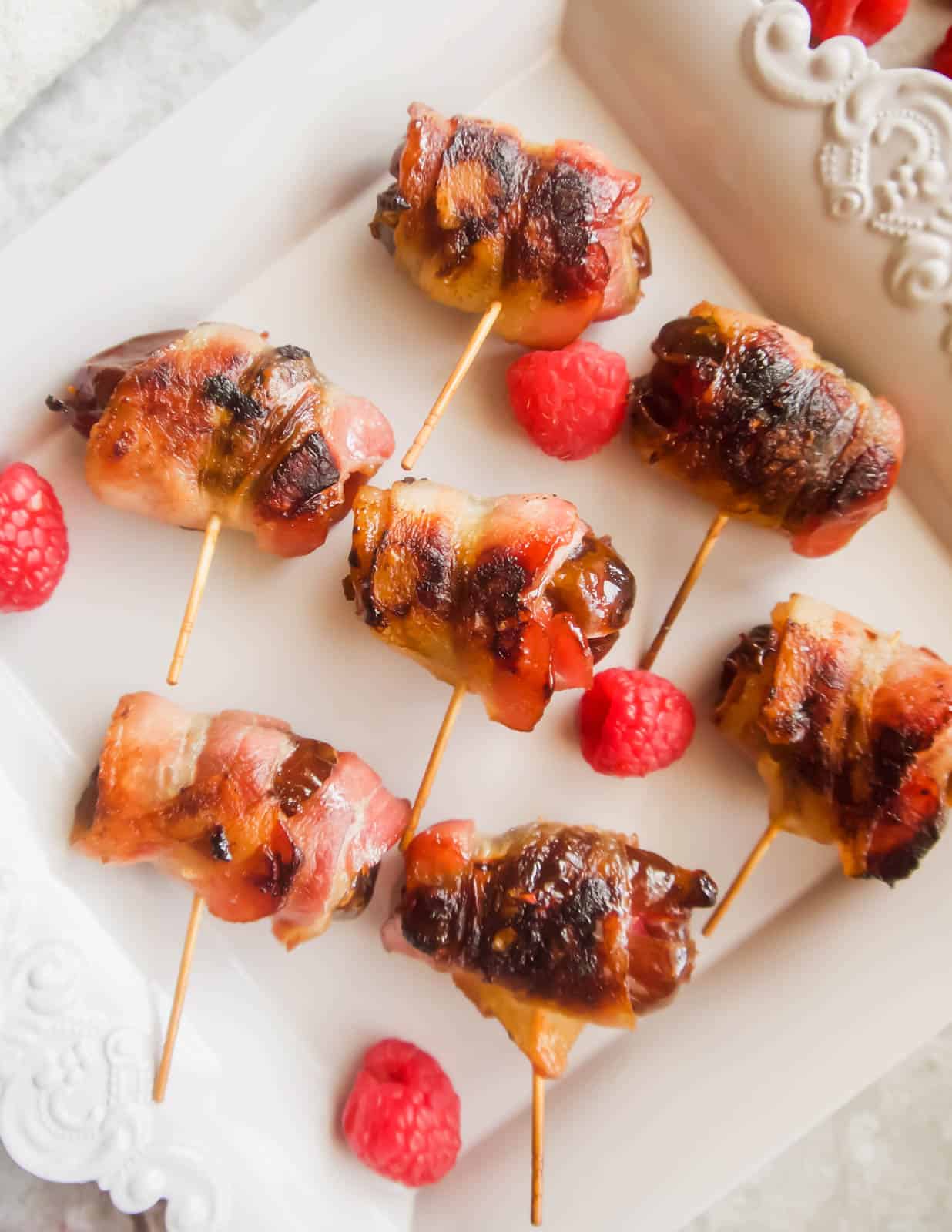 Freshly cooked raspberry stuffed dates wrapped in crispy bacon.