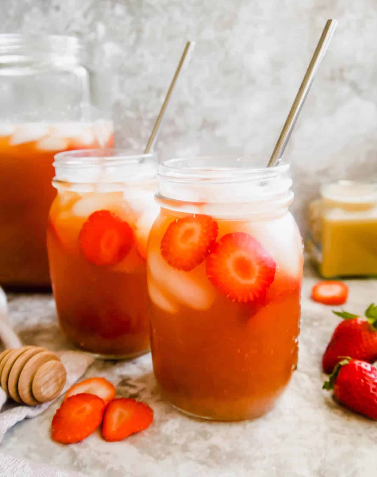 Strawberry Sweet Tea in mason jars with straws in them.