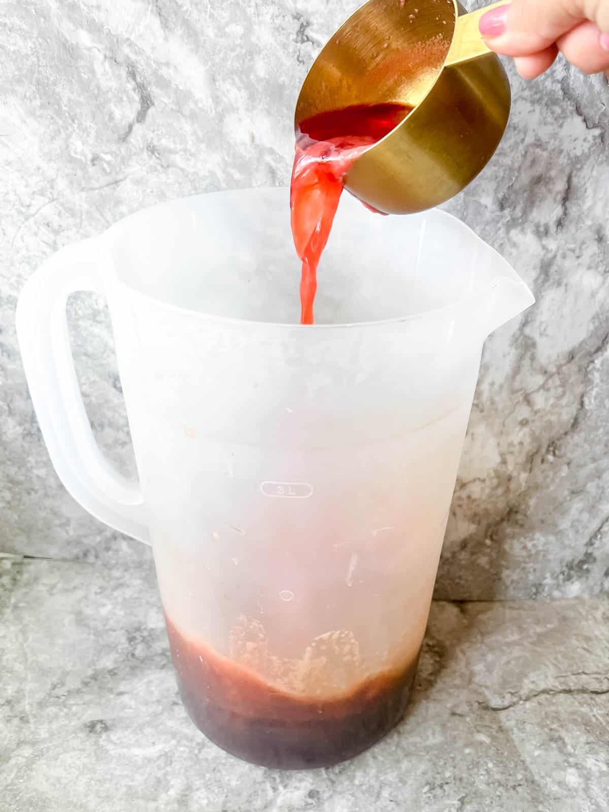 Adding strawberry juice to iced tea.