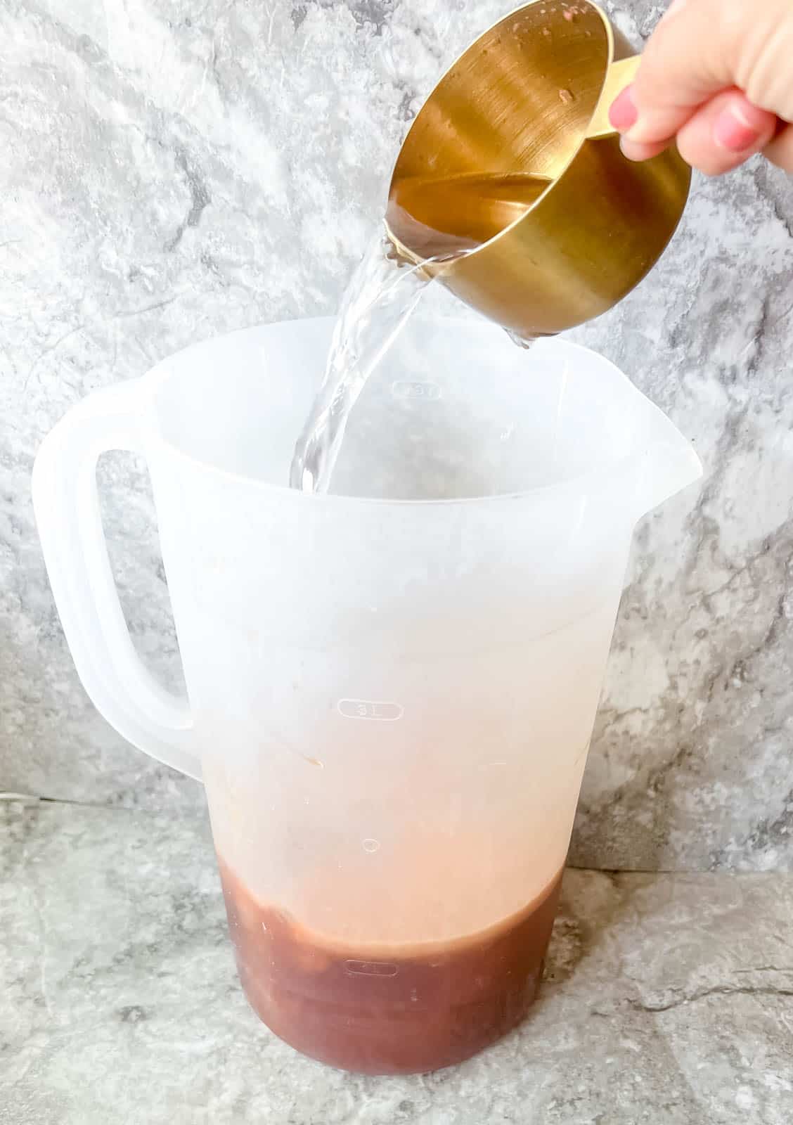 Adding water to strawberry sweet tea.