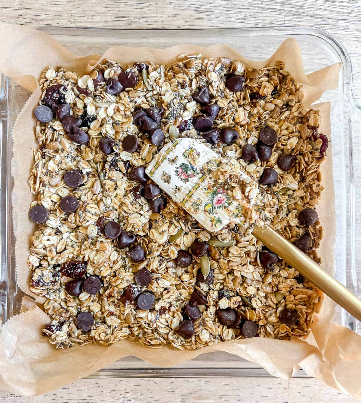 Almond butter granola bars pushed into pan.