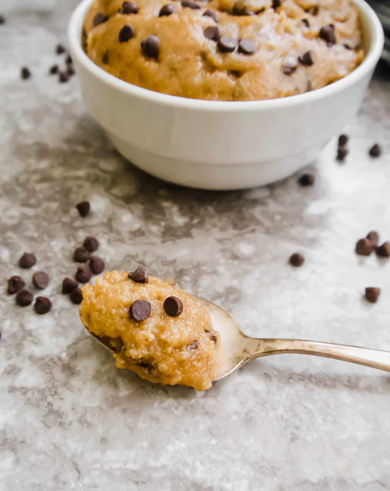 Edible chocolate chip cookie dough on a spoon.