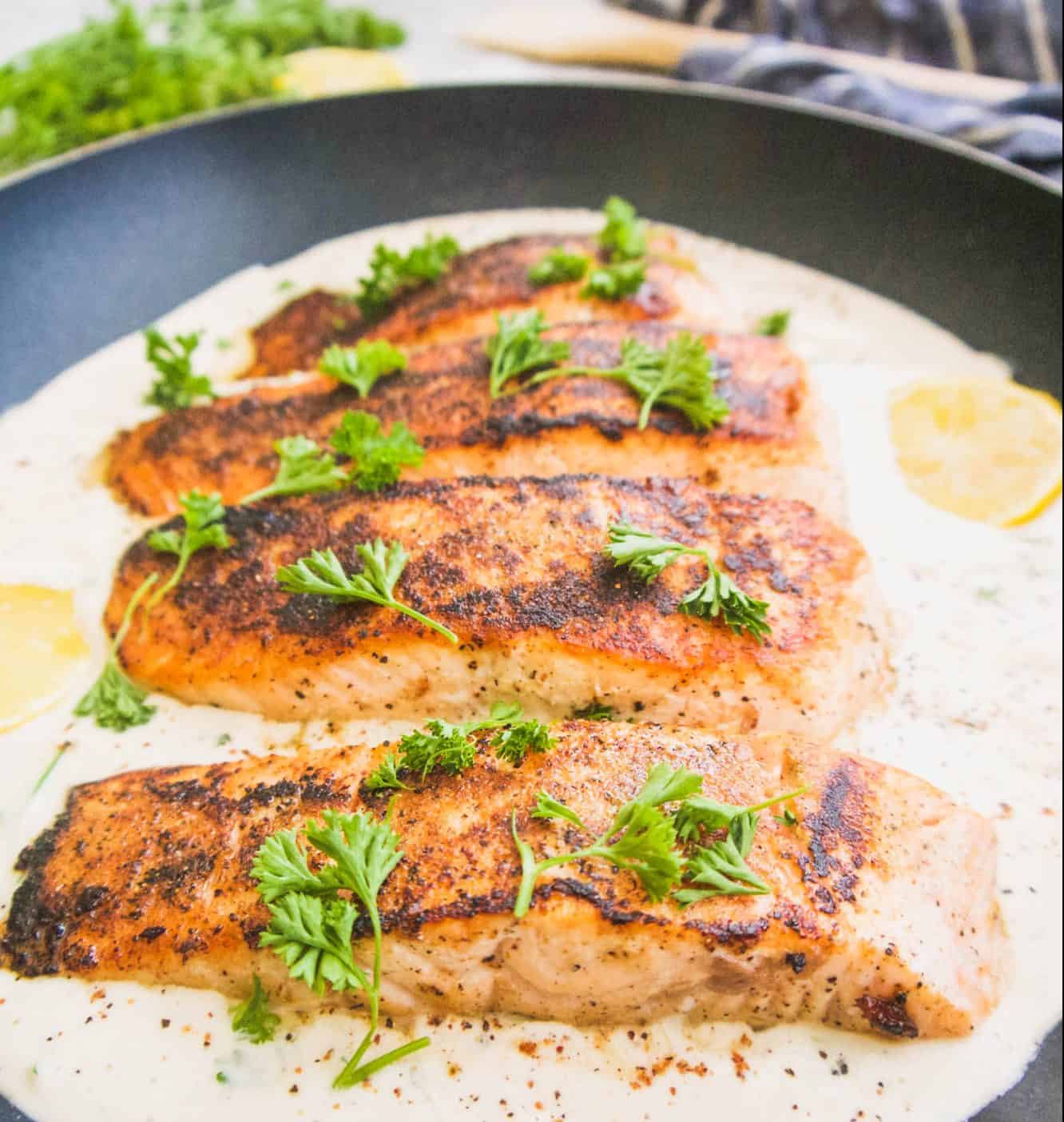 Whole30 salmon in a frying pan with coconut cream sauce.