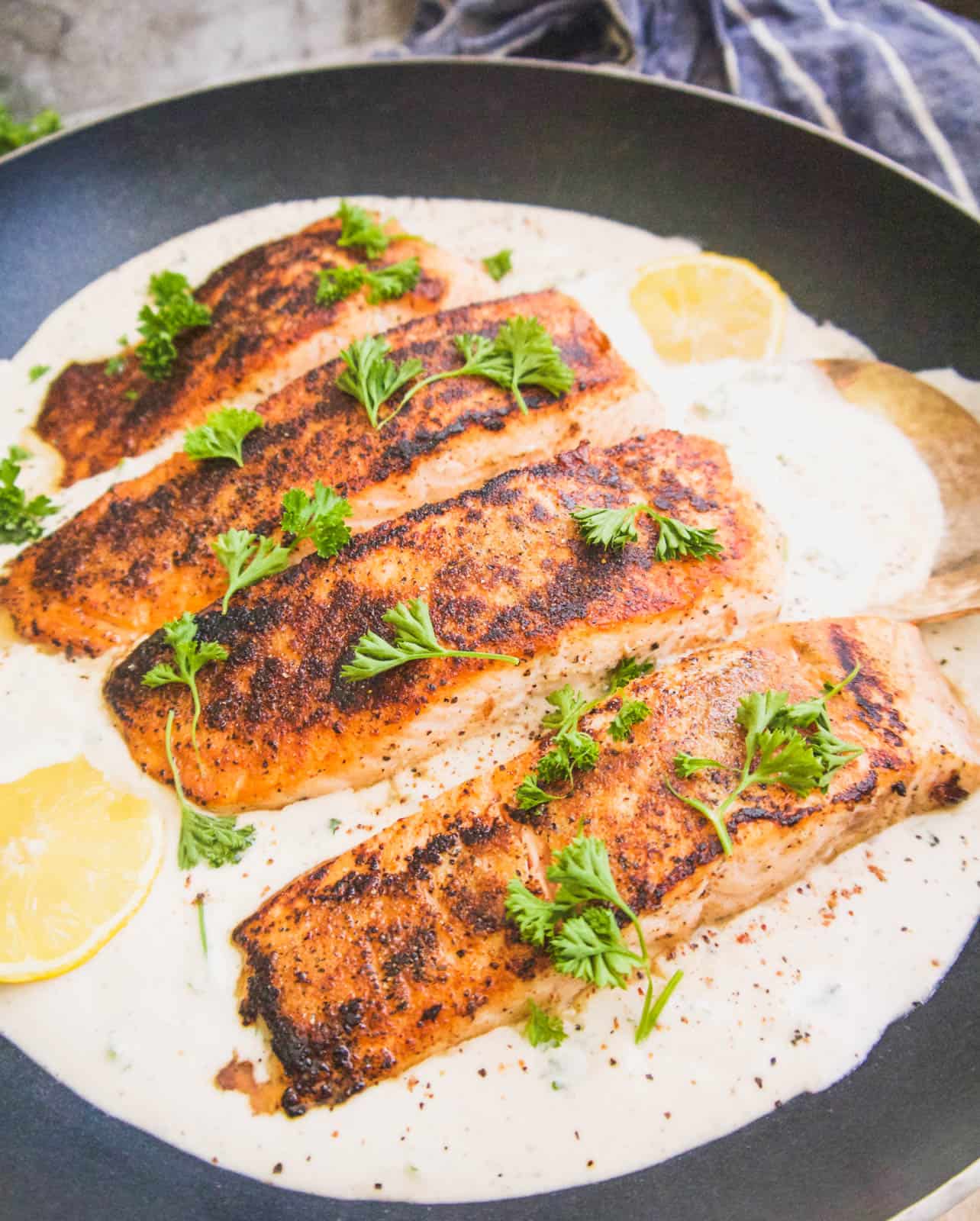 Salmon in a frying pan with coconut cream sauce.