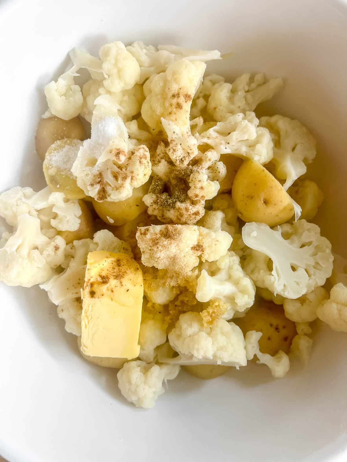 All the potato cauliflower mash ingredients in a bowl together.