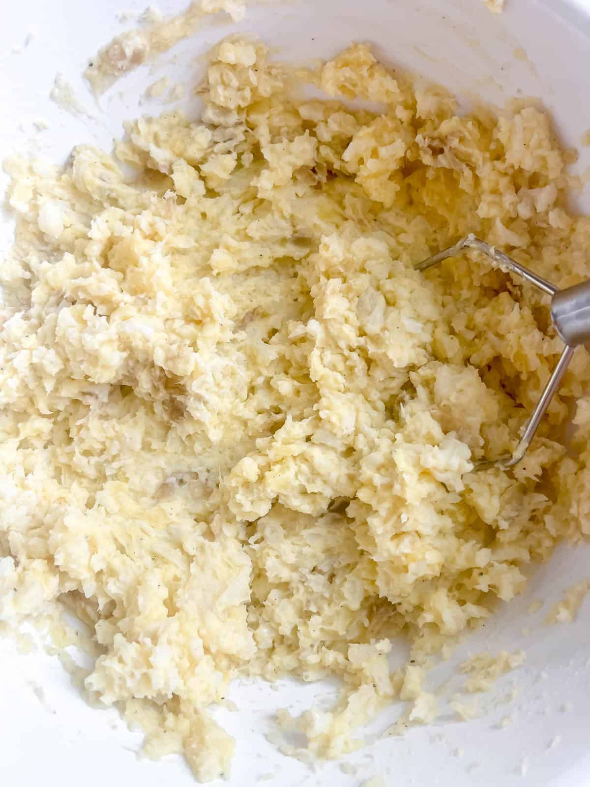 Mashed cauliflower and potatoes in a bowl.