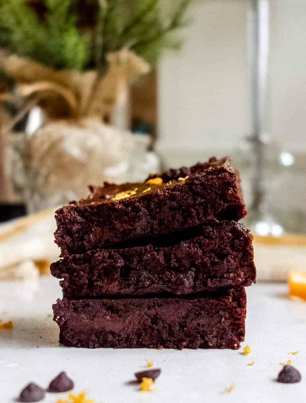 Photo of three chocolate orange brownies stacked on top of each other. 