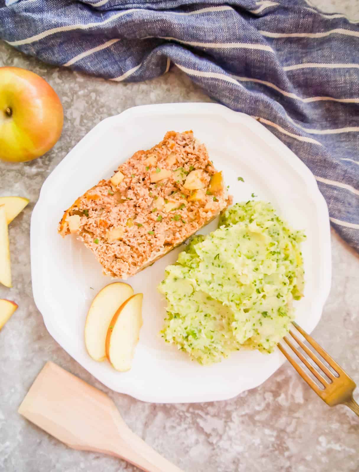 A slice of paleo meatloaf with apples in it on a plate.