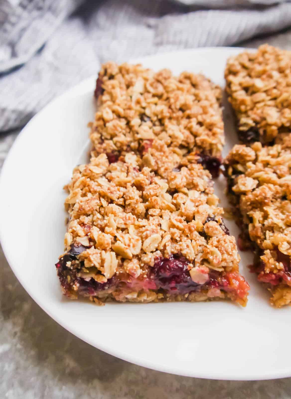 Oat berry bars cut into squares and on a plate.
