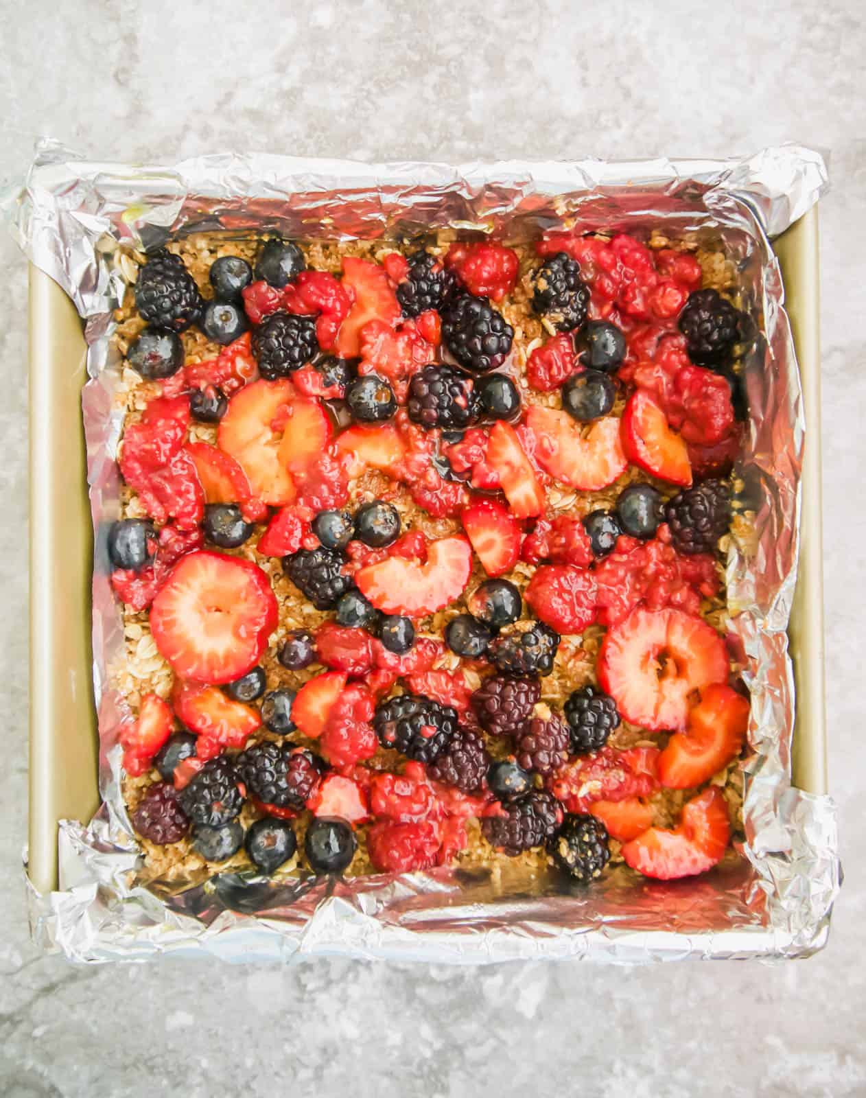 Fruit layer added to the oat layer in a pan.