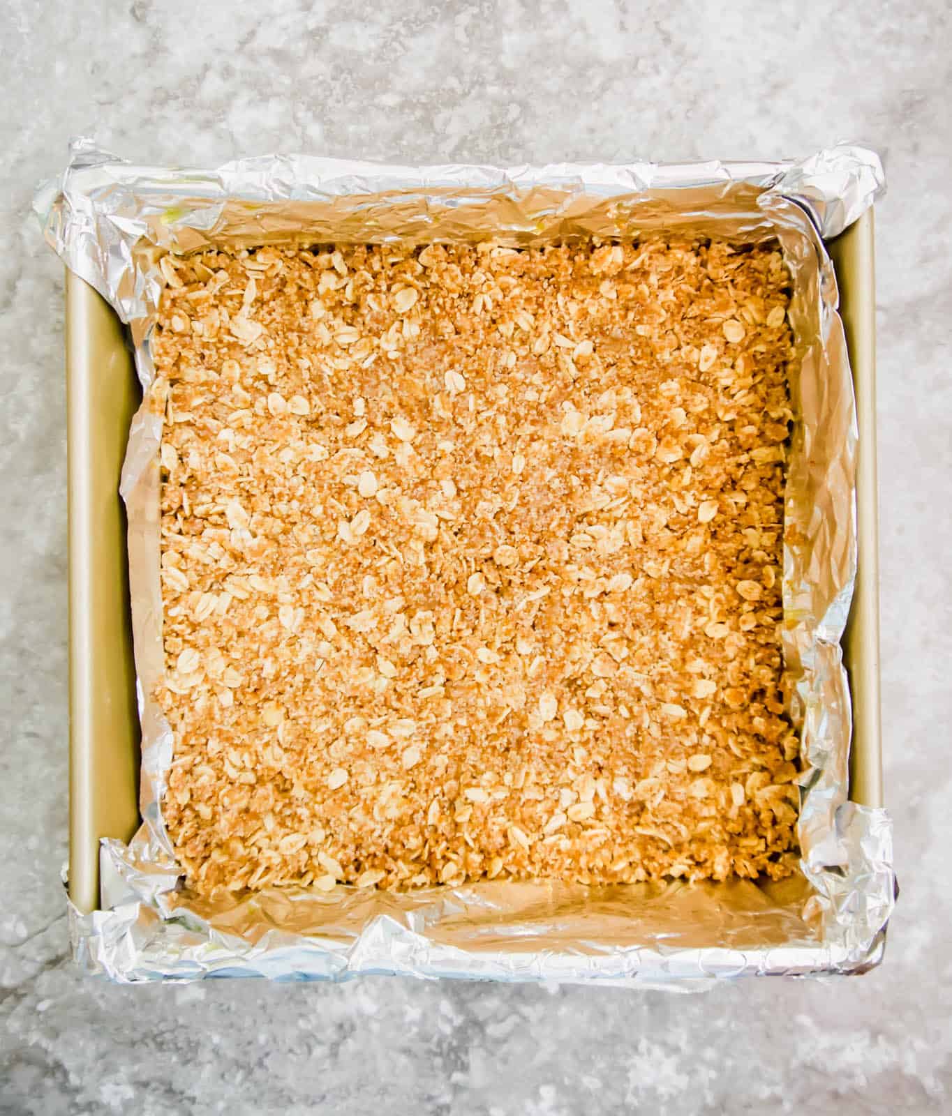 Oat layer of the bars in a pan.