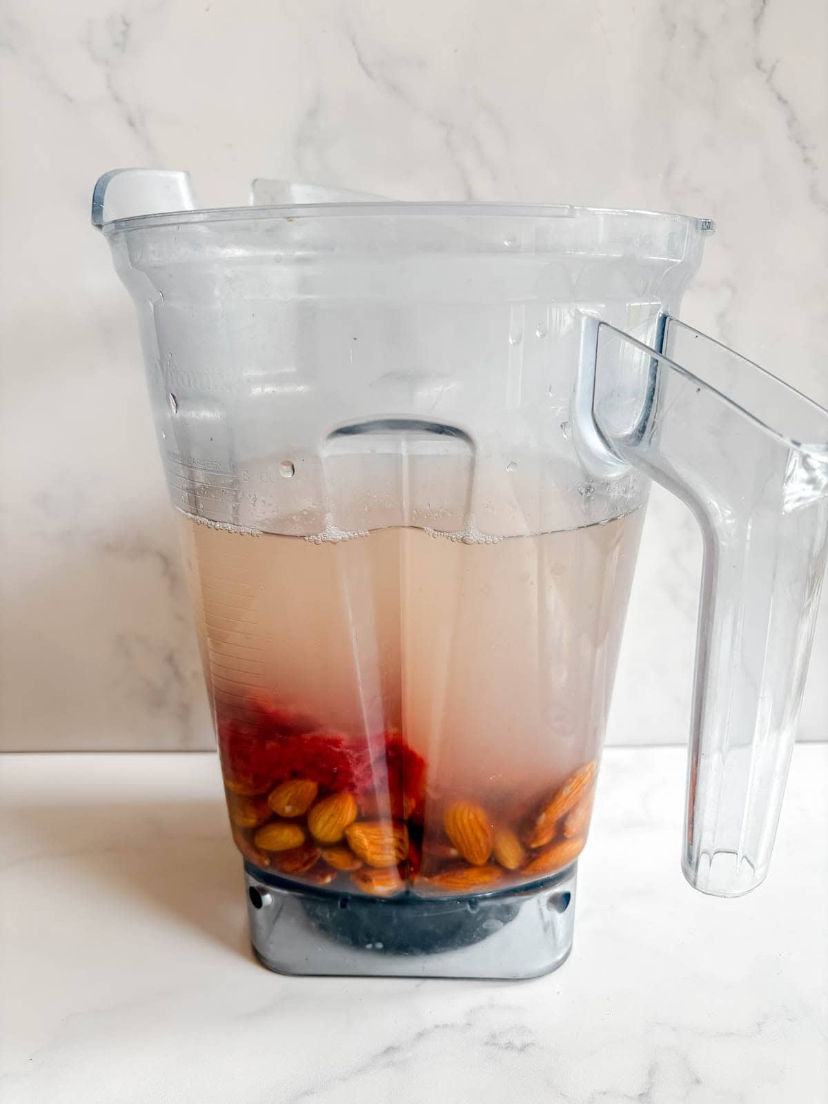 Almonds, water and strawberry pulp in a blender.