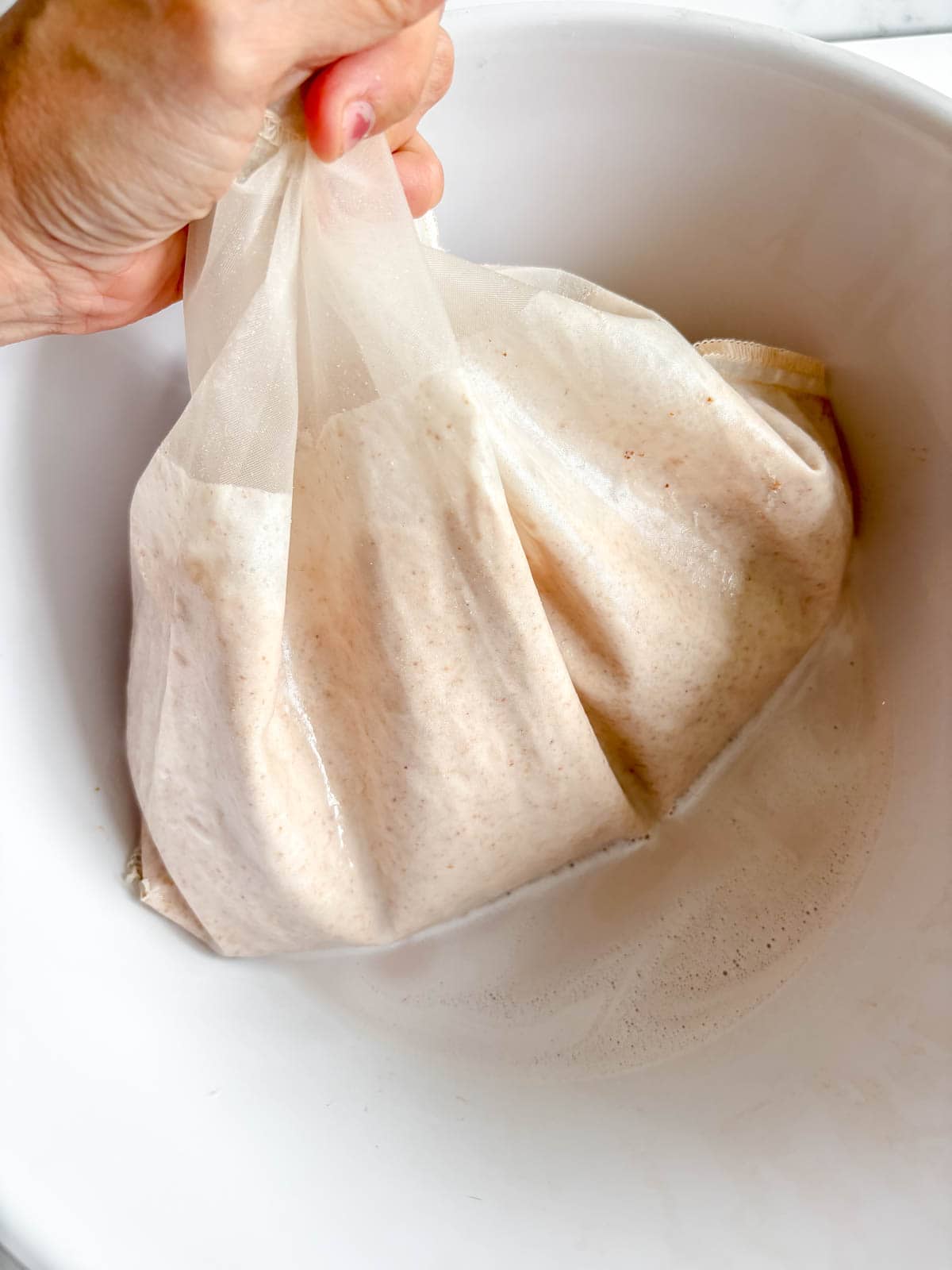 Almond water mixture in a nut milk bag.