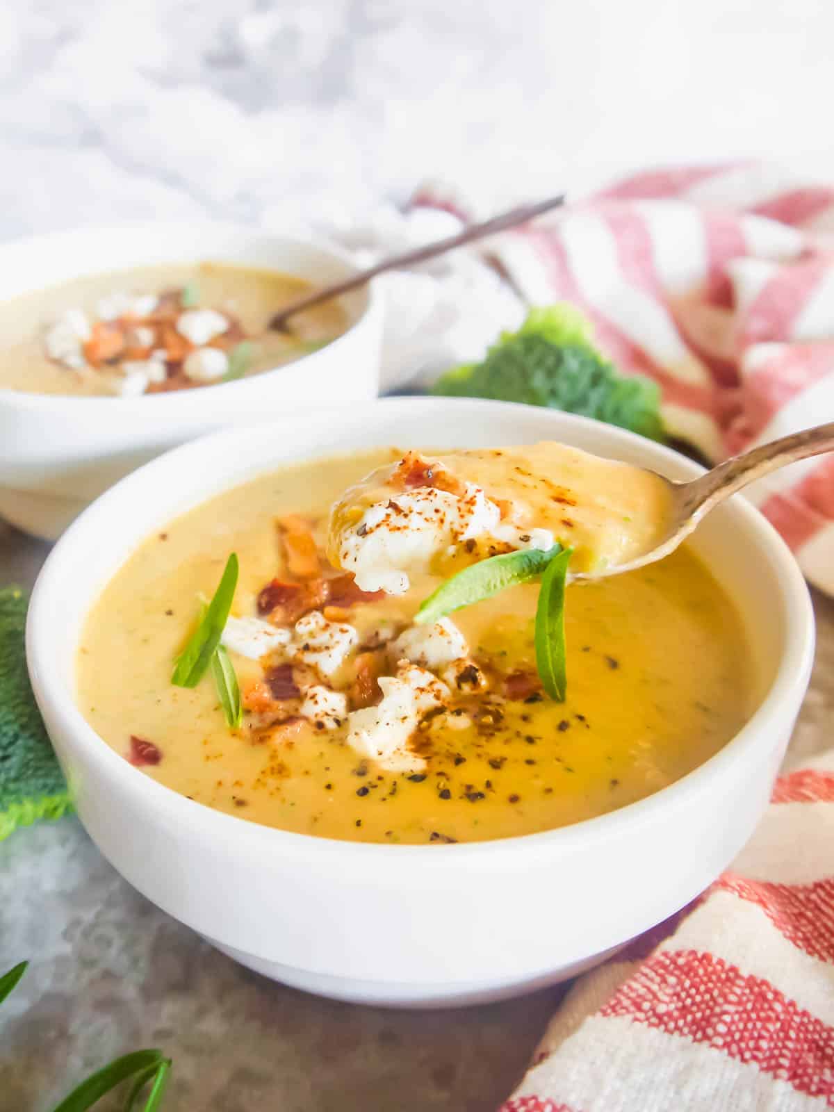 Broccoli sweet potato soup in a bowl with a spoon in it.