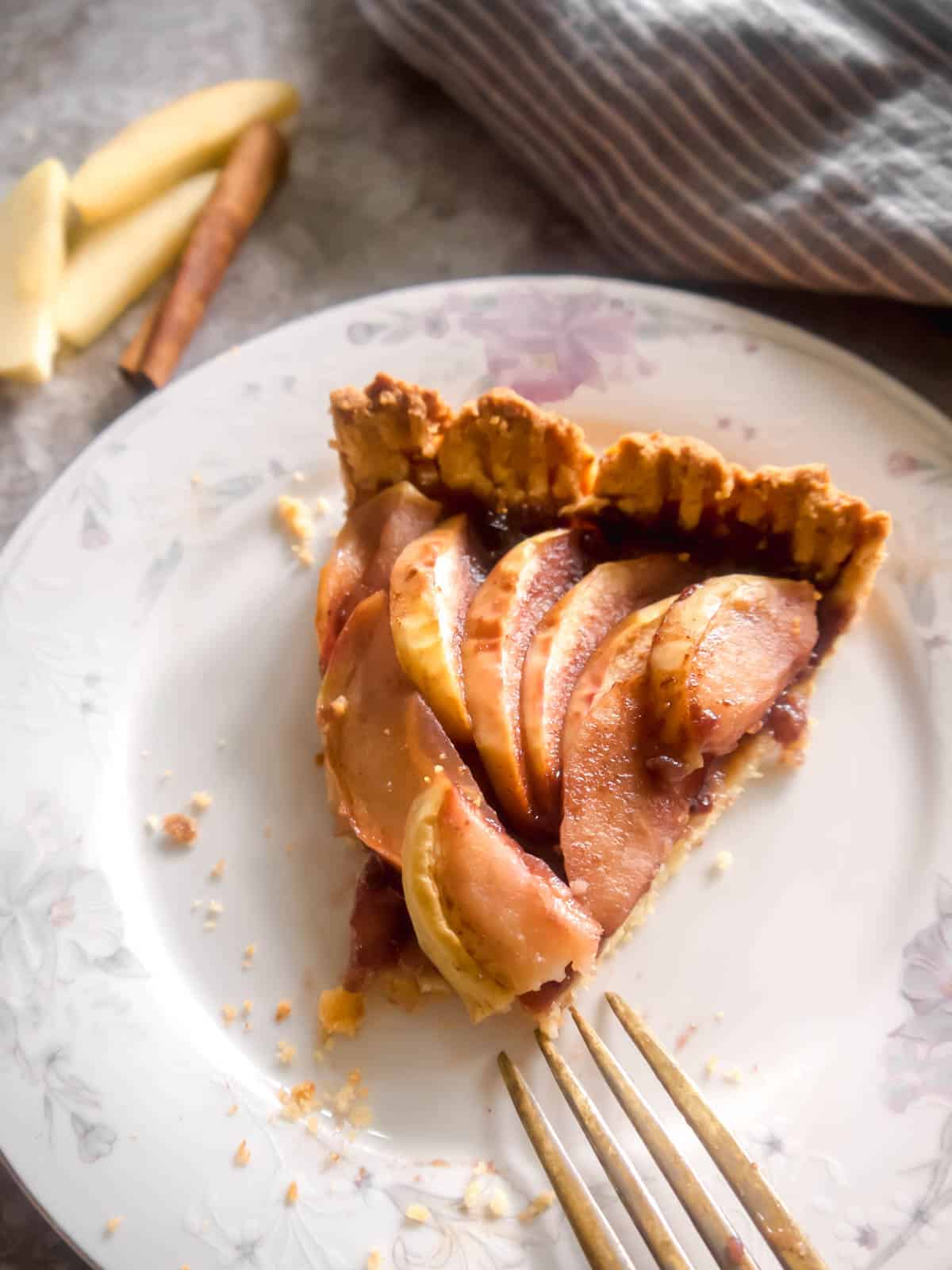 Slice of almond flour apple tart on a plate.